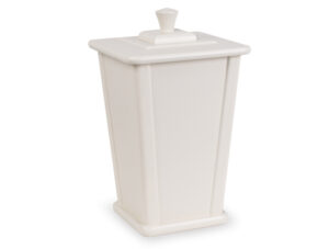 Benfärgad urna med fyrkantig form och lock, avsedd för aska efter kremering.