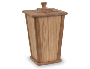 Träurna i ljus ek med fyrkantig form och profilerat lock, avsedd för förvaring av askan efter kremering.